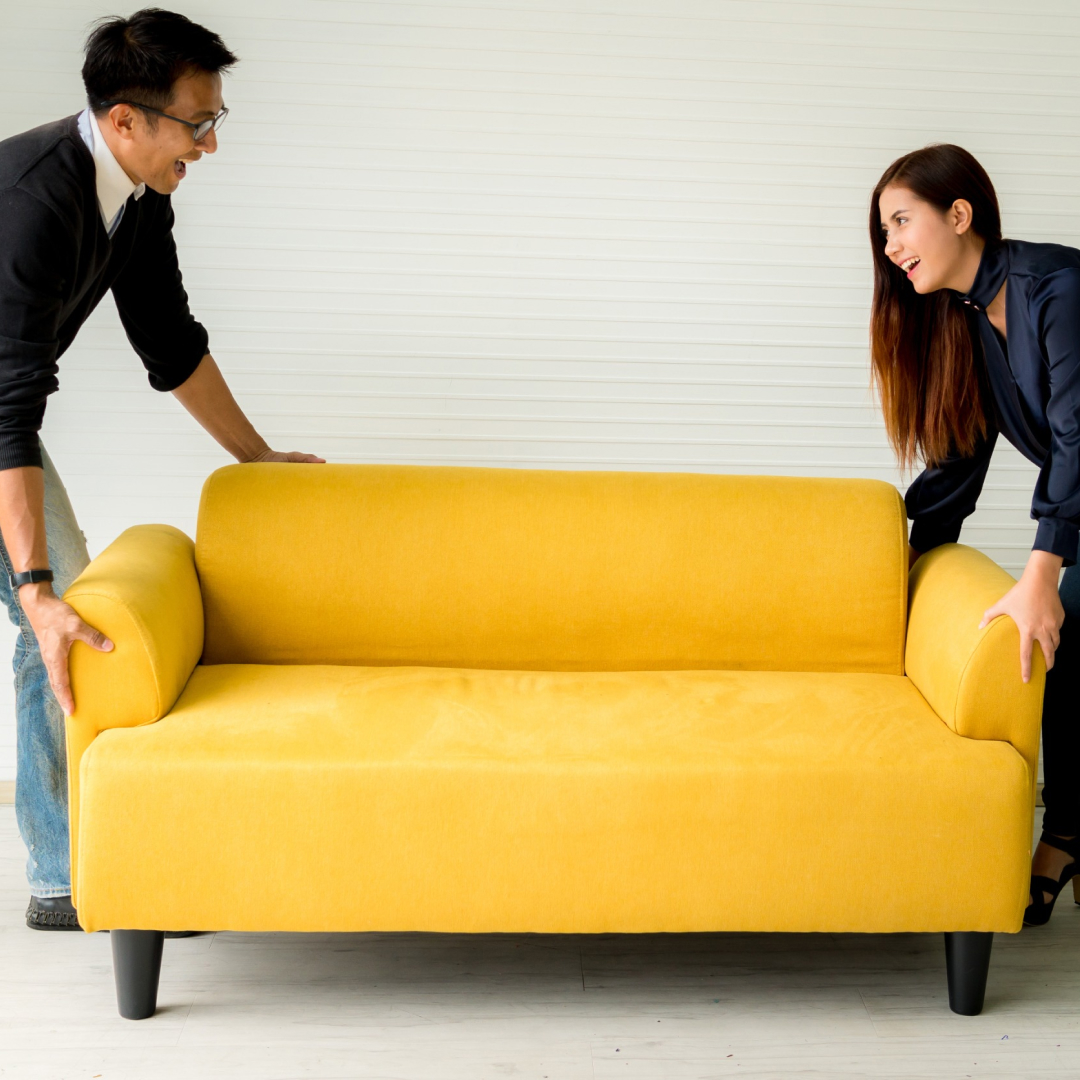 Man and woman moving a yellow sofa from one of the best furniture stores in Rockledge, Fl.