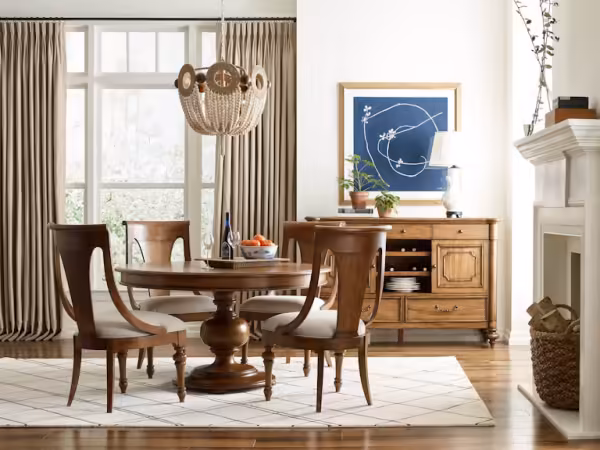 Elegant dining room with wooden table, chairs, chandelier, and sideboard.