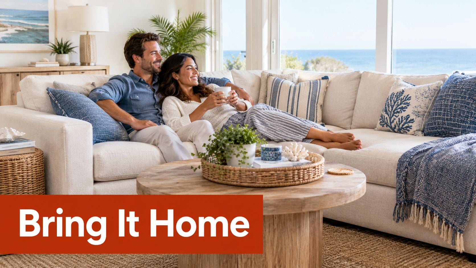 A smiling couple relaxes on a plush cream-colored sectional sofa in a bright, coastal-style living room.