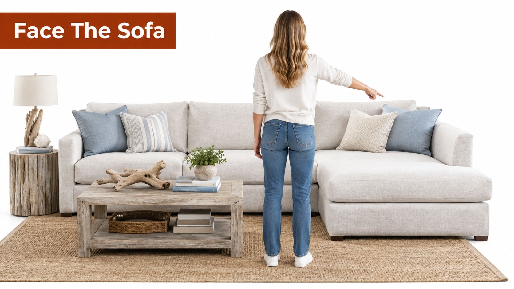 A woman stands with her back to the camera, pointing toward a light gray sectional sofa.