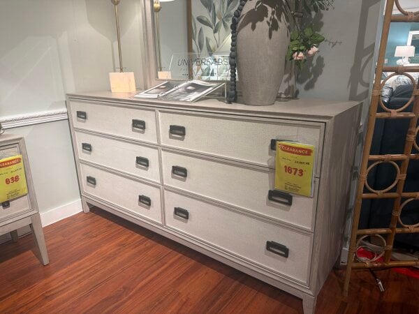 Light gray six-drawer dresser with textured front and clearance tag.