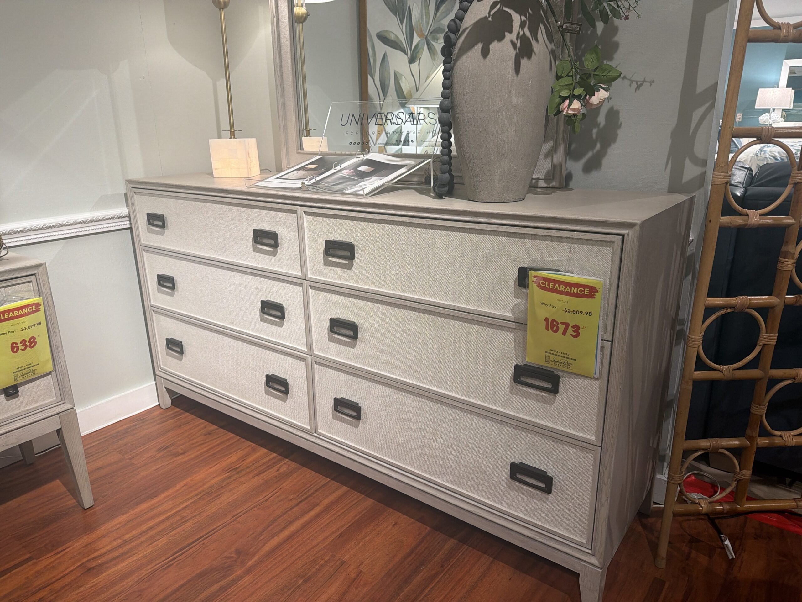 0afd4f6d-9572-4385-97a8-b565b3883983-47358-0000162a4b4db318_file Light gray six-drawer dresser with textured front and clearance tag.