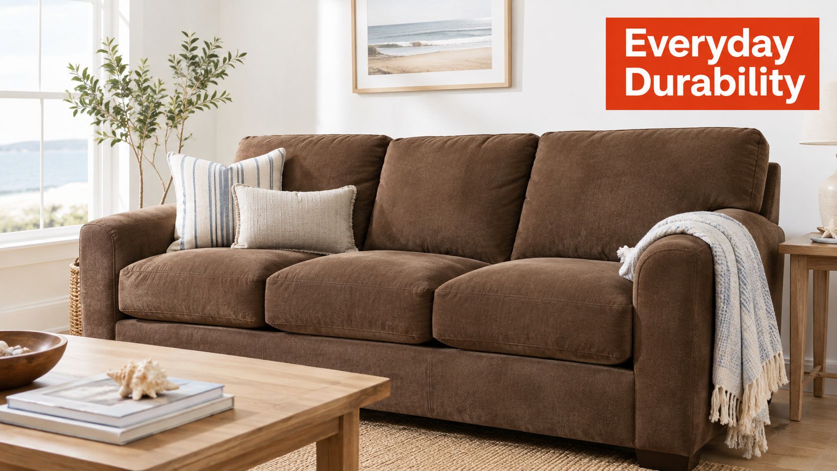 A brown microfiber couch featuring throw pillows and a draped blanket, set in a cozy living room.