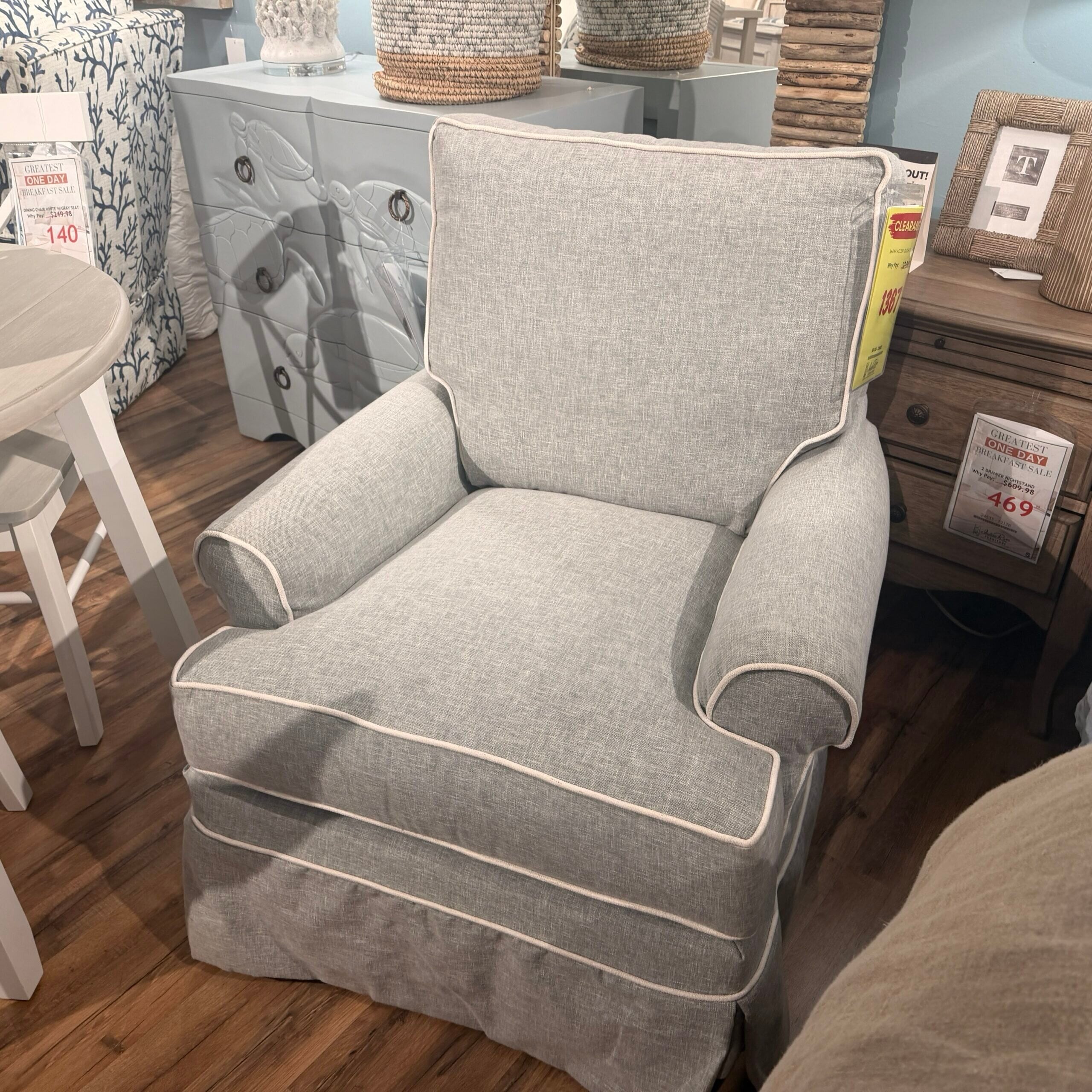 img_1758 Light blue upholstered armchair with white piping in furniture store.