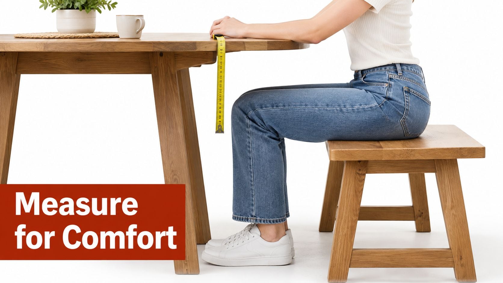 A person measuring the clearance under a round dining room table while sitting on a wooden bench.