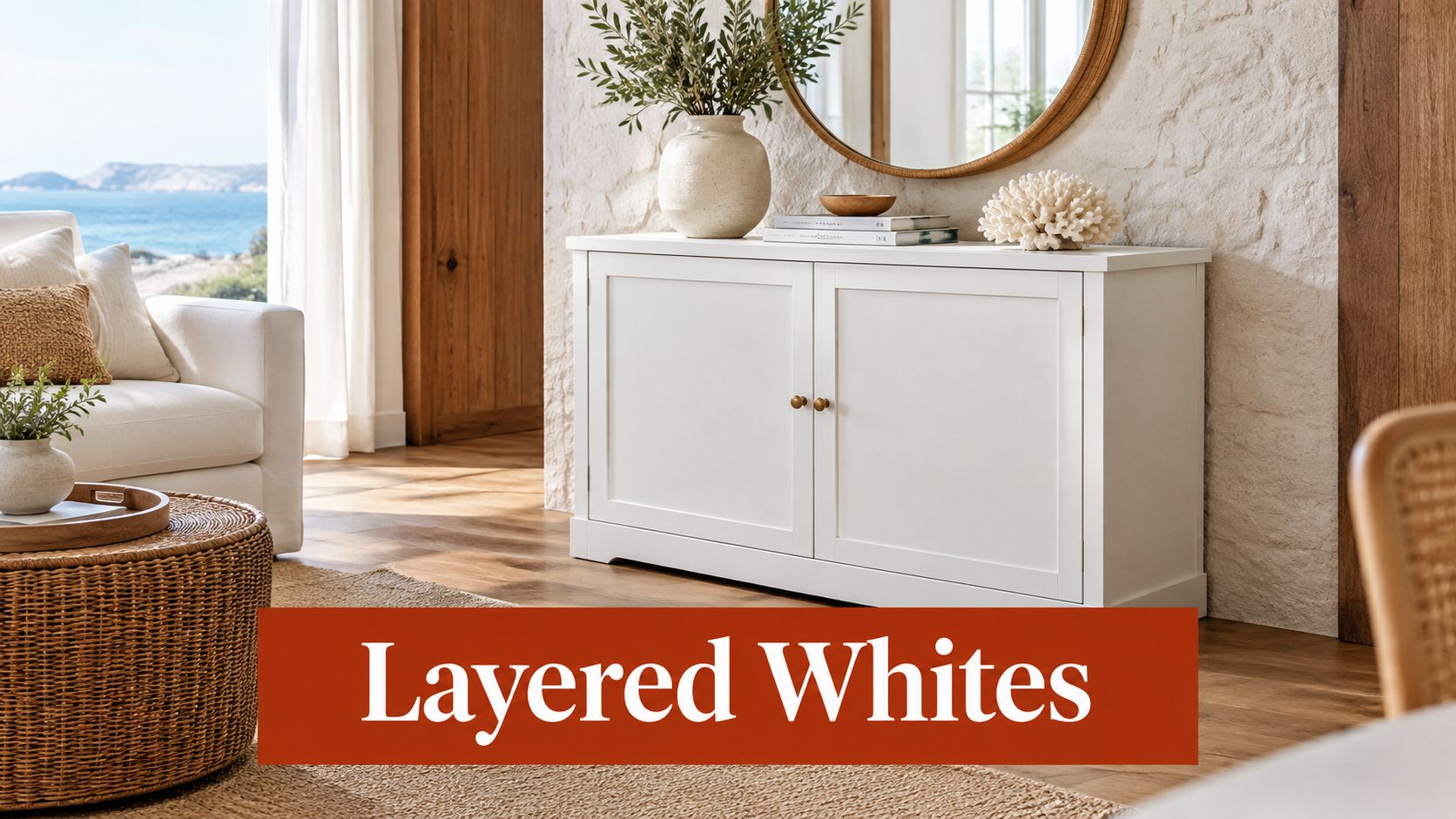 A modern white accent cabinet placed against a rustic stone wall in a bright, coastal-inspired living room.